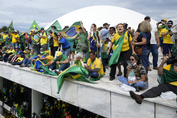 Bolsonaro supporters stand on the roof of the National Congress building in Brasilia after storming it.