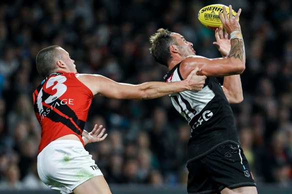 Jeremy Finlayson takes a mark under pressure from Essendon’s Nik Cox.