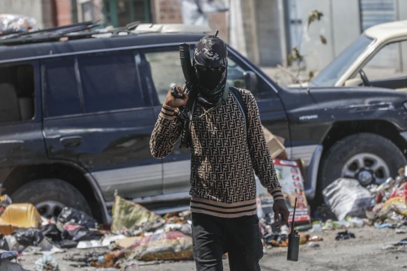 An armed member of the G9 and Family gang patrols a roadblock in Port-au-Prince, Haiti, on Monday.