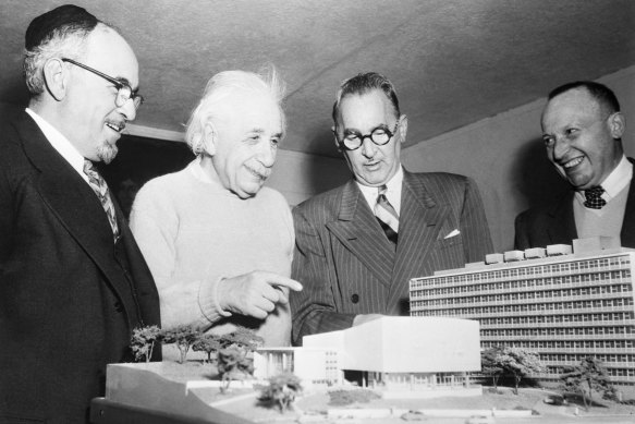 Professor Albert Einstein (second from left) receives a scale model of the Albert Einstein College of Medicine, then under construction, on his 75th birthday on March 14, 1954.