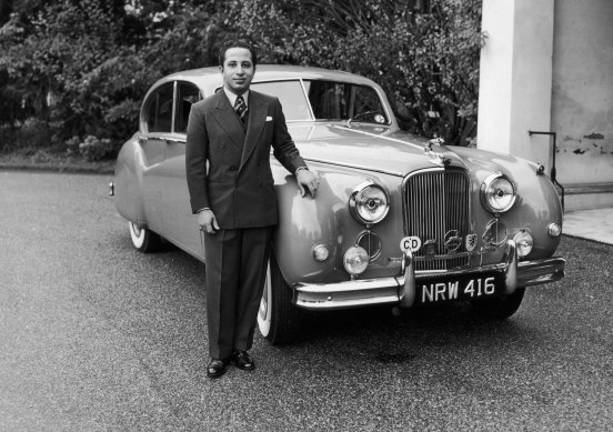 King Faisal II of Iraq poses with a Jaguar at Stanwell Place, UK.