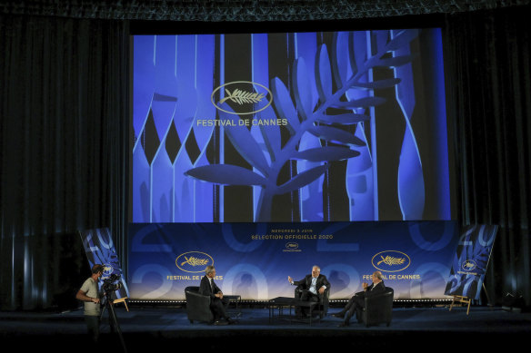 Cannes Festival director Thierry Fremaux, centre, festival president Pierre Lescure, right, and journalist Laurent Weil talk during the presentation of the festival line-up, in an empty cinema in France on Wednesday.