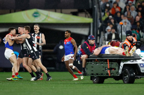 Jack Viney clashes with Magpie Brayden Maynard as teammate Angus Brayshaw is taken off the field on a stretcher.