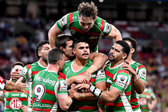 Latrell Mitchell is mobbed by Rabbitohs teammates after scoring against the Dolphins.