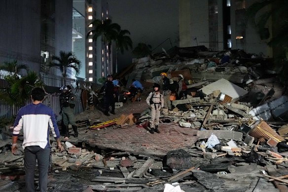 La gente cammina tra le macerie di Caracas dopo il terremoto.