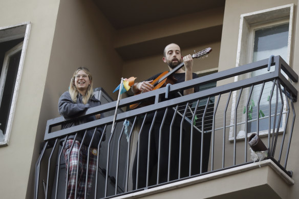 A man in Milan plays guitar on the balcony of his home as part of a flash "non-mob" launched throughout Italy to help people cope with being in lockdown.