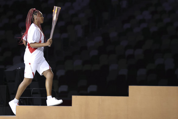 Naomi Osaka carries the Olympic torch during the Tokyo Games opening ceremony.