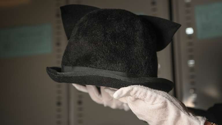 Carolyn Laffan holds Chrissy Amphlett's hat, with cat's ears attached.