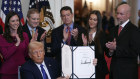 President Donald Trump holds the document after signing the Laken Riley Act during an event in the East Room of the White 