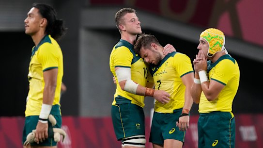 Australia’s Nick Malouf, center left, and teammate Josh Turner embrace as the team reacts to its defeat by Fiji in their men’s rugby sevens quarter-final match in Tokyo.