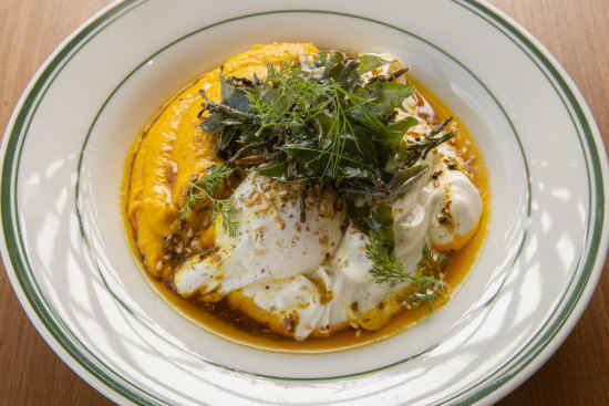 Vadouvan eggs: Poached eggs drizzled with spiced ghee and garnished with zaatar over herbed carrot puree and lemon labne.