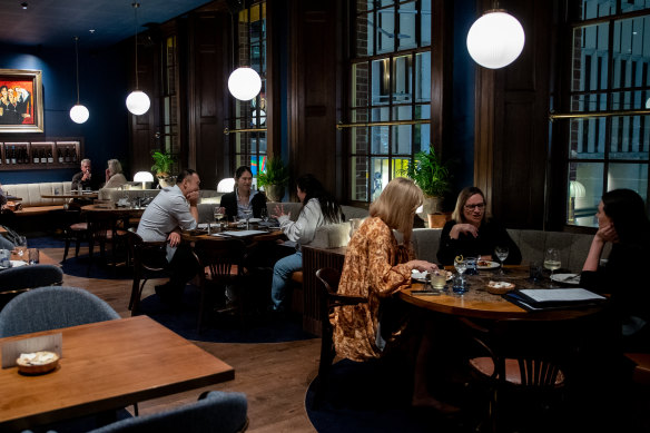 Velvet booths under the original timber windows in The Sanderson dining room.