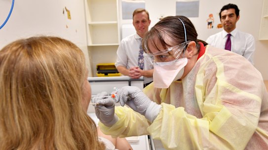 Clinical nurse consultant Janice Geary demonstrates the testing procedure for Queensland Health Minister Steven Miles at the Prince Charles Hospital.
