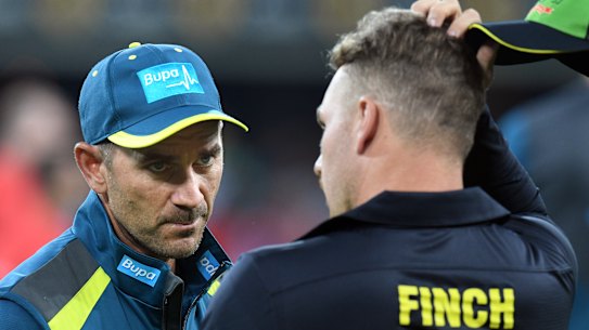 Finch speaks with coach Justin Langer.