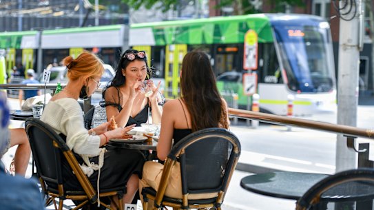 Patrons at Mr Tulk cafe soak up the sunshine in Melbourne, where restrictions are set to ease again on Sunday. 