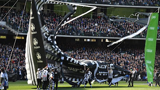 Magpie horror: Collingwood banner rips apart in wind before grand final