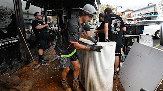 Locals start cleaning out shops and businesses along Pulteney Street in Taree.