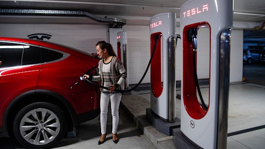 Vicky Wang, charging up her Electric car at a Tesla station in the Sydney shopping centre at Broadway.