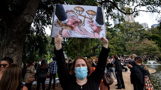 A protester brandishes an anti-Liberal sign at  March 4 Justice in Melbourne.