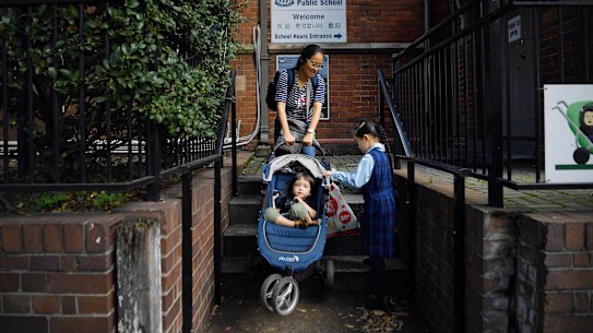Linda Gu drops her daugher off at her school on her first day back on Wednesday.