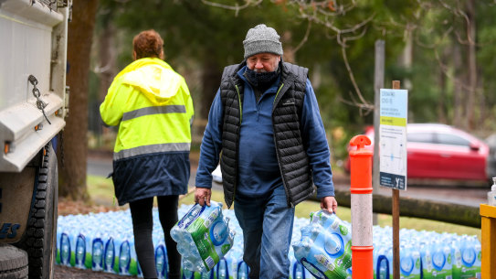 Kallista resident Jeff Seigerman carries bottles of water brought in for residents after they were warned not to drink water from their taps. 