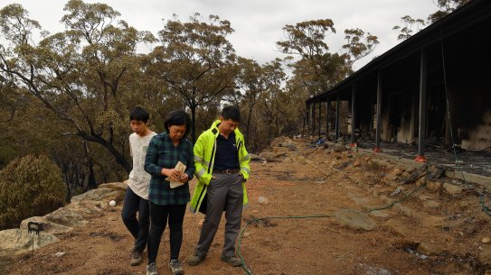 Balmoral residents Gabriel stands with his parents Helena and Justin in the days after their Balmoral home was destroyed by the Green Wattle Creek fire in December 2019.