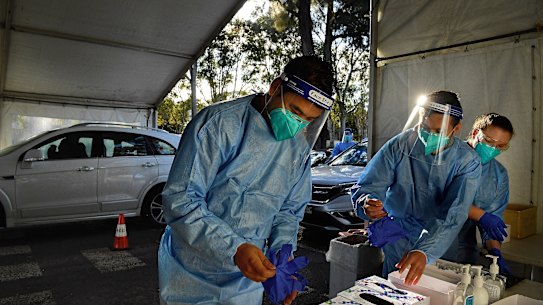Laverty Pathology staff Don on personal protective equipment PPE, before conducting COVID-19 tests at the Roselands Drive through testing clinic. In the 1hr since opening the staff have conducted 150 COVID-19 tests. Roselands, NSW. 7th July, 2021. Photo: Kate Geraghty