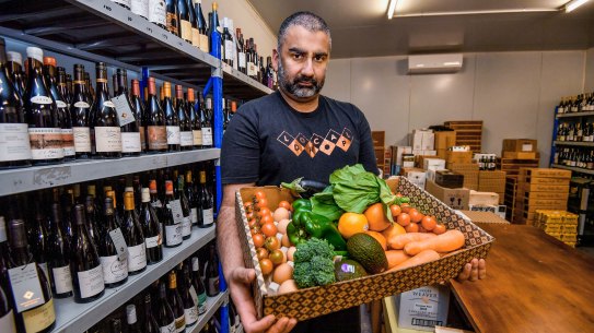 Jagdev Singh, who owns the Local Drop in East Brunswick, with one of the produce boxes he will deliver to people in need.