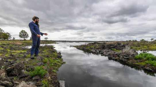 Winda-Mara Budj Bim Ranger Aaron Morgan next to a channel in one of the aquaculture systems at Tae Rak (Lake Condah).