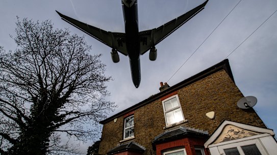 Aircraft come in to land at Heathrow airport over nearby houses in London.