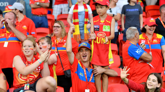 Good as gold: Suns fans cheer on their team at Metricon Stadium.