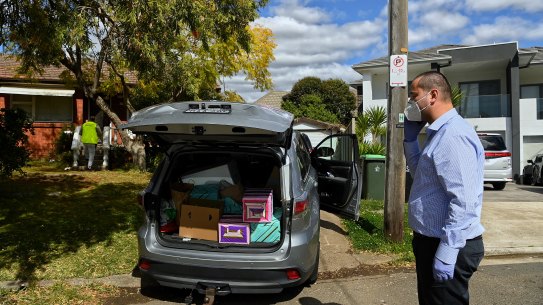 Bilal El-Hayek takes a phone call outside a Greenacre home while Aner Yassine delivers food to a household of ten.