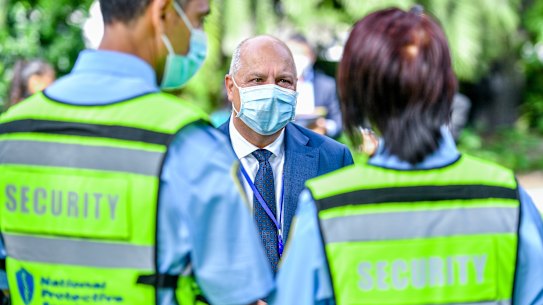 Victorian Treasurer Tim Pallas and security personnel outside Parliament in February.