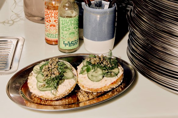 Masses Bagels’ hot smoked trout bagel with pickled cucumber, soft herb salad &amp; capers.