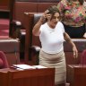 Lidia Thorpe appears to throw papers towards Pauline Hanson, with Fatima Payman (back left) seated behind them.