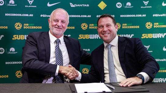 Graham Arnold shakes hands with Football Australia boss James Johnson after signing on as Socceroos coach for four more years.