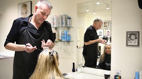 Russell James attends to the locks of client in his Sydney CBD salon.