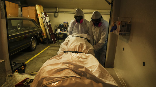 Workers at a Sydney funeral parlour take delivery of the body of a COVID-19 casualty. 