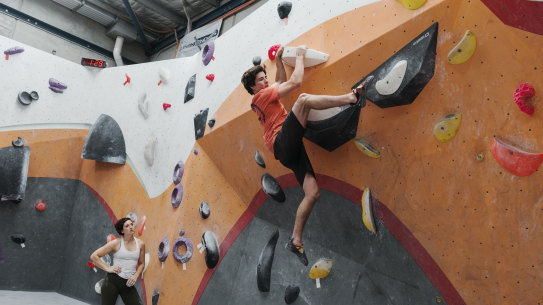 Up and away: Emma Horan watches Ben Abel complete at a practice climb at Nomad Bouldering in Annandale.