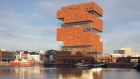The Museum aan de Stroom features red brick volumes interspersed with undulating glass panels.