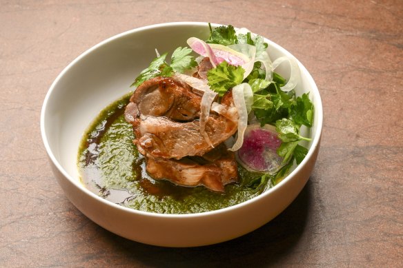 Lamb neck is served with green mole, and showered with herbs and thinly sliced radish.