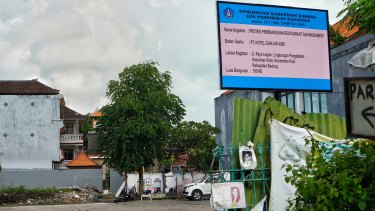 A building permit sign for a 700-sqm building on the 800-sqm site was placed above fading photos of the bombing victims at the former Sari Club site in Bali on Wednesday.