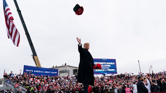 President Donald Trump throws a hat to supporters as he arrives at his third and final rally on Tuesday (Monday US time) in Pennsylvania.