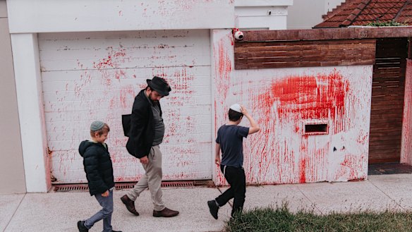 Members of the Jewish community walk past the Dover Heights home targeted in an antisemitic attack.