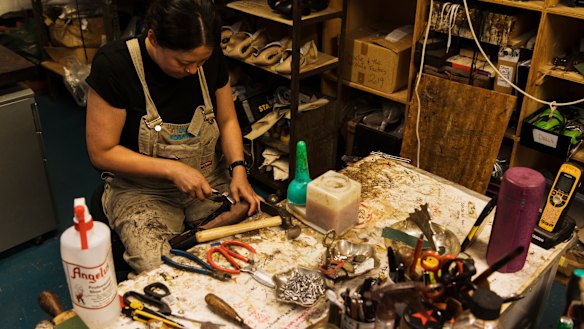A cobbler handmakes a pair of boots that will be worn in Hamilton.
