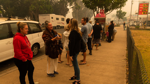 People lined up to use the public telephone in Narooma as power and telecommunications were down on New Year's Day. 