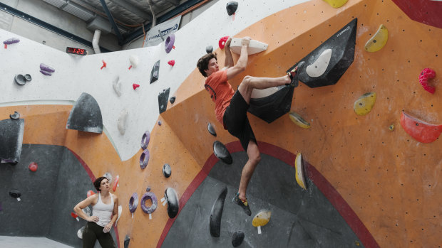 Up and away: Emma Horan watches Ben Abel complete at a practice climb at Nomad Bouldering in Annandale.