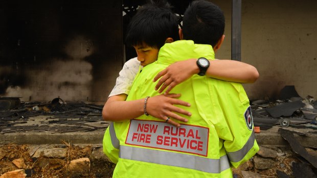 Justin, in a borrowed RFS jacket, comforts his son Gabriel.