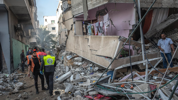 Palestinian civil defence members search for people in the rubble of a destroyed building after an Israeli air strike in Gaza City on May 16.