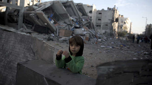 A Palestinian boy stands next to the rubble of Hamas' al-Aqsa TV station building which was hit by Israeli airstrikes on Monday, in Gaza City.